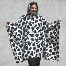 Load image into Gallery viewer, Girl wearing hooded blanket in a black and white cow print fleece fabric with front pocket
