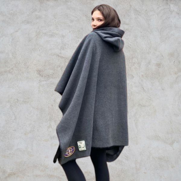 Girl with her back to the photo wearing grey hooded blanket camp blanket badge blanket with scout badges sewn on